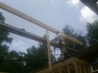 Carpenter setting a ridge beam over a new addition frame — Ice Dam Removal by Roofing Brothers in Old Bethpage