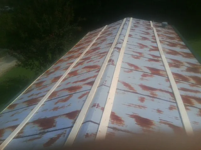 Rusted metal roof panels with new wood purlins before replacement — Storm Damage Roof Repair in Old Bethpage by Roofing Brothers