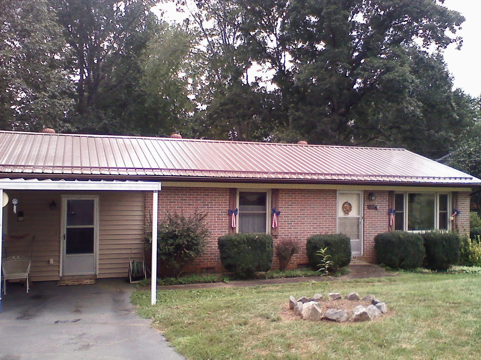 Bronze metal roof and carport on a brick ranch home — Roof Repair work by our crew in Old Bethpage